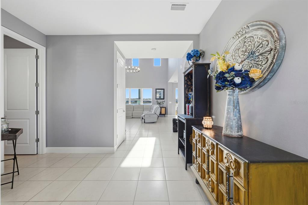 A tiled entryway leads into a bright living area with a decorative console table — 137 AZURE MIST WAY, DAYTONA BEACH, FL