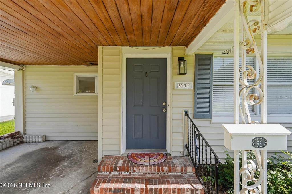 A front entrance features a gray door, brick steps, and a covered concrete porch — 5239 GLENWOOD AVENUE, JACKSONVILLE, FL