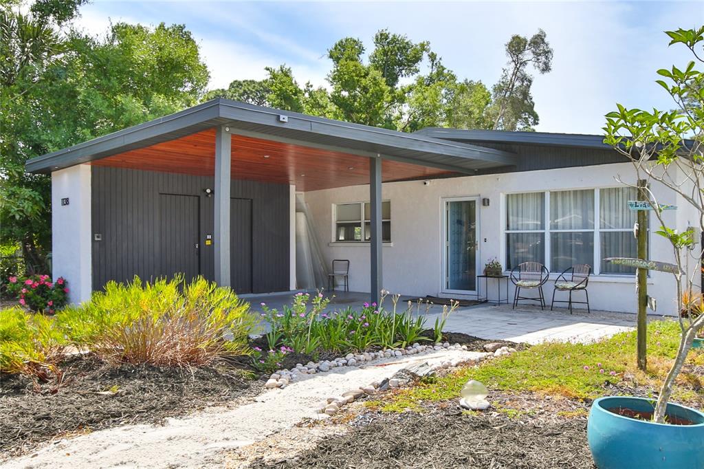 A single-story house features a covered carport with wood ceiling and a white exterior — 1138 47TH STREET, SARASOTA, FL