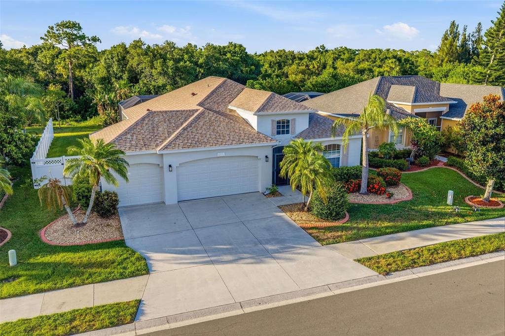 A single-story suburban house with a three-car garage, palm trees, and a landscaped front yard — 6631 63RD TERRACE E, BRADENTON, FL