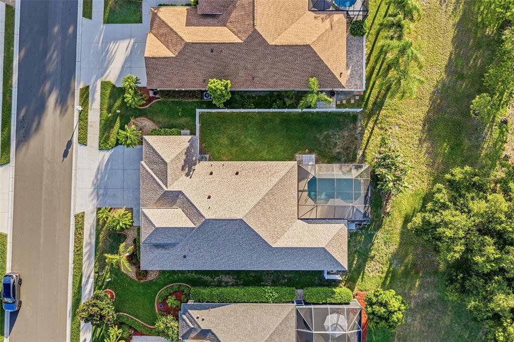 An aerial view shows a suburban house with a screened pool and a fenced backyard — 6631 63RD TERRACE E, BRADENTON, FL
