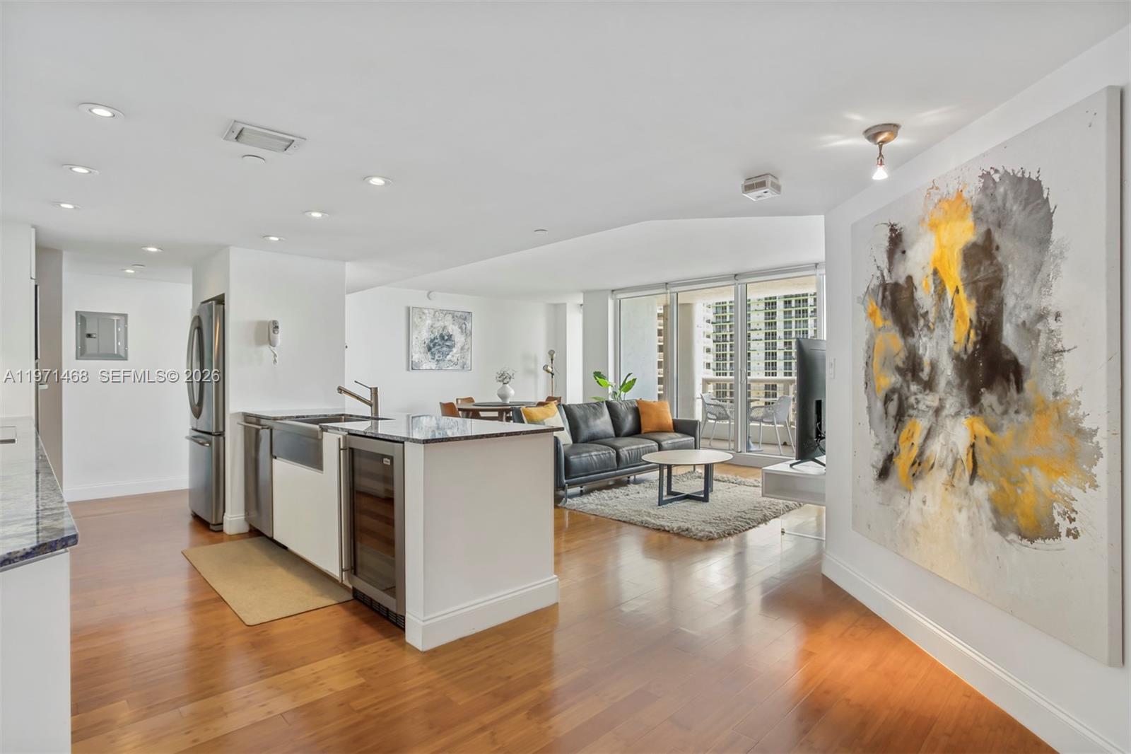 A modern lobby features a white marble reception desk, terrazzo flooring, and a decorative wall installation — 1717 N Bayshore Dr # 2740, Miami FL 33132, MIAMI, FL