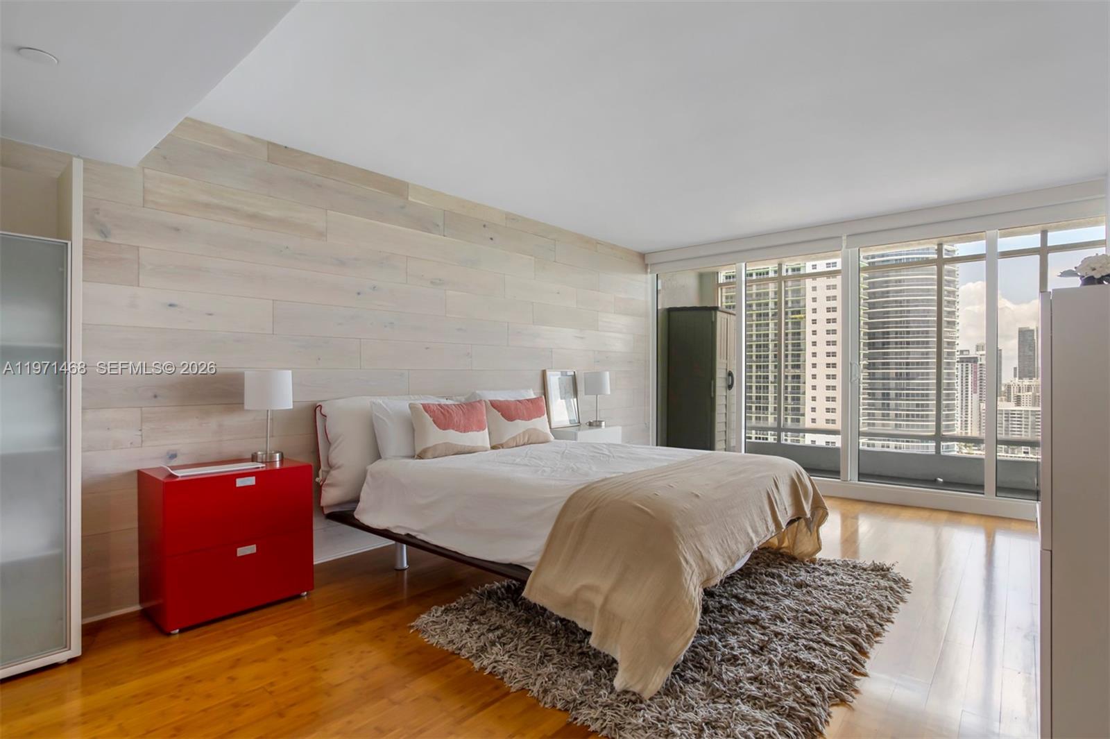 An open-concept living area features a kitchen island, hardwood floors, and a large abstract painting — 1717 N Bayshore Dr # 2740, Miami FL 33132, MIAMI, FL