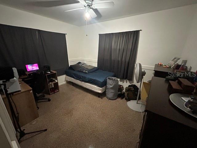 A bedroom features a bed, a desk with a computer, and dark window curtains — 399 BETH DRIVE, SANFORD, FL
