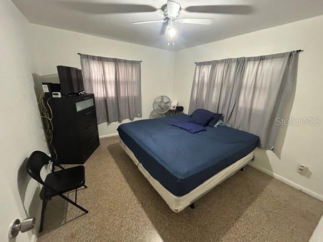 A bedroom features a large bed, a black dresser with a television, and gray curtains — 399 BETH DRIVE, SANFORD, FL