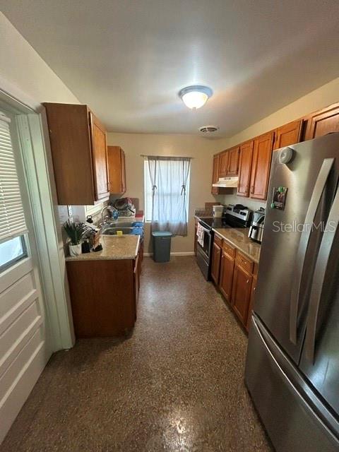 A kitchen features wood cabinets, stainless steel appliances, and a window with curtains — 399 BETH DRIVE, SANFORD, FL