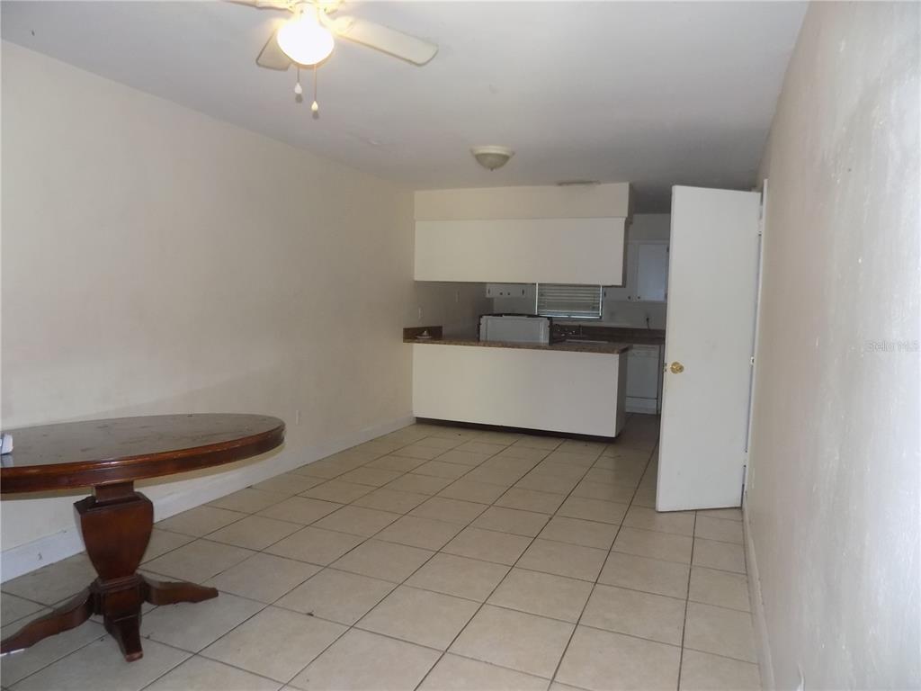 An open-concept room features a dining area with a round table and a kitchen — 713 SW 69 STREET, GAINESVILLE, FL