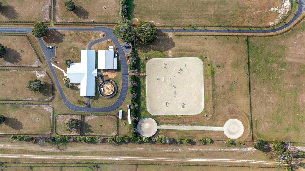 An aerial view shows a horse farm with a house, riding arena, and training pens — 5575 NW 100TH STREET, OCALA, FL