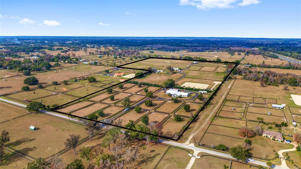 An aerial view shows a large rural property with fenced pastures, a house, and outbuildings — 5575 NW 100TH STREET, OCALA, FL
