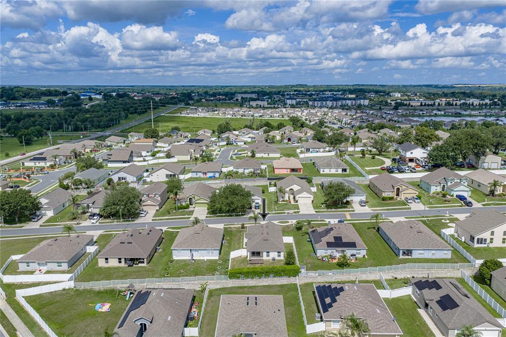 An aerial view shows a suburban neighborhood with single-family homes and fenced backyards — 7552 JENO STREET, ZEPHYRHILLS, FL