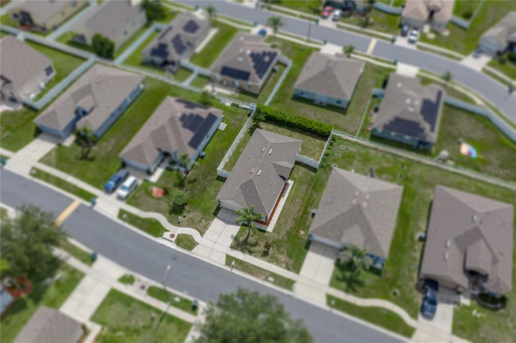 An aerial view shows a suburban neighborhood with single-family homes and paved streets — 7552 JENO STREET, ZEPHYRHILLS, FL