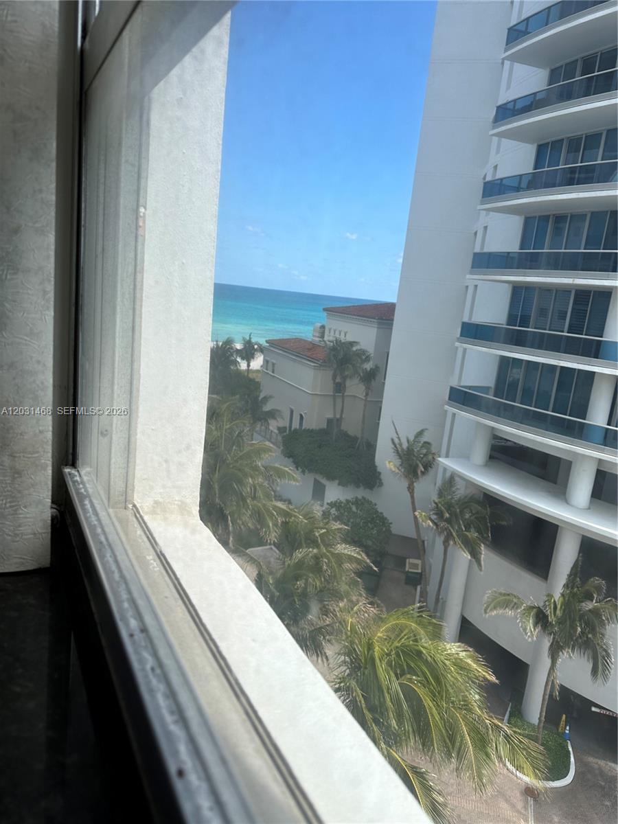 A view of the ocean and a neighboring building from a window — 6039 Collins Ave # 728, Miami Beach FL 33140, MIAMI BEACH, FL