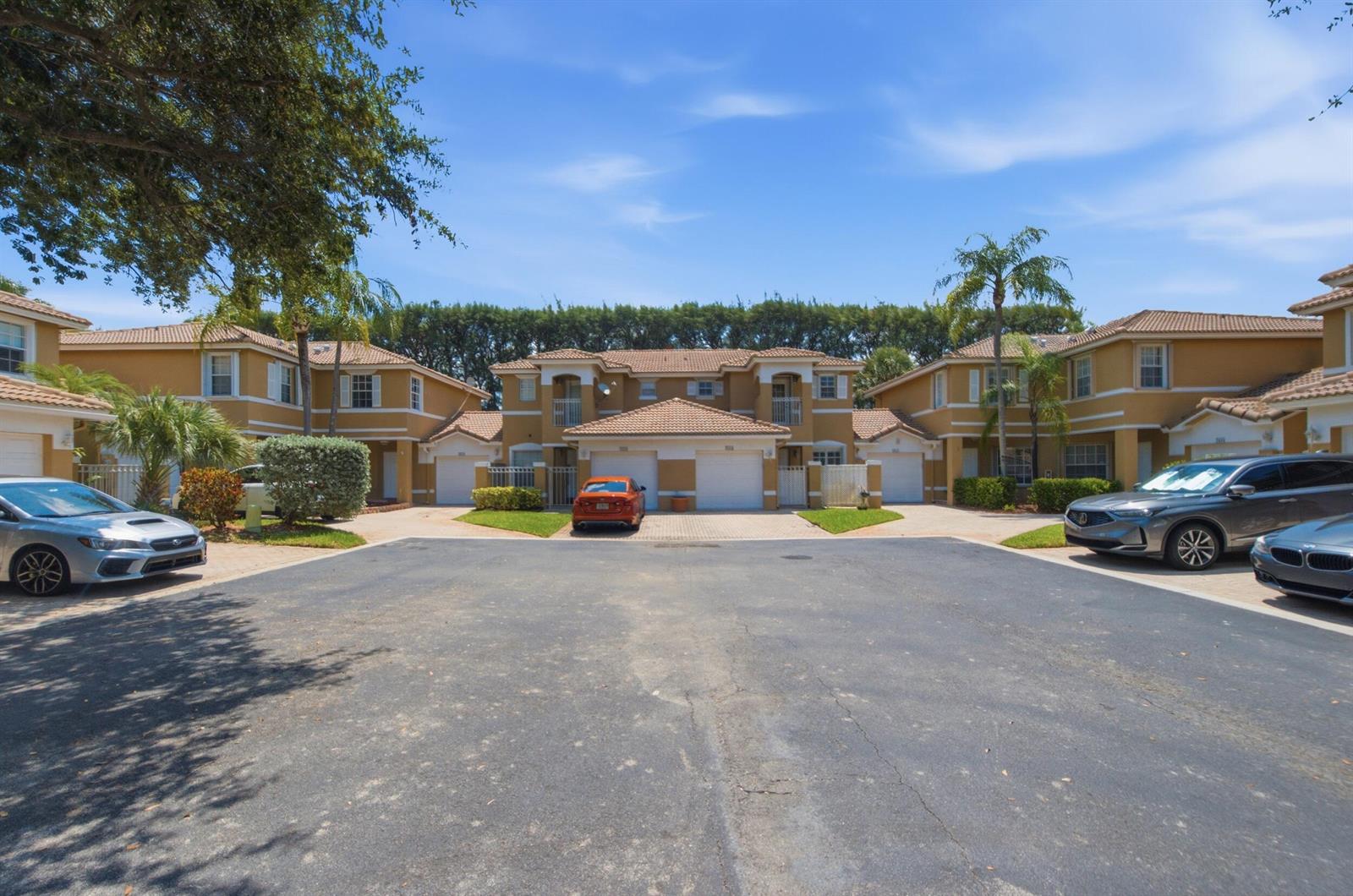 A row of two-story townhomes with tan stucco walls and tile roofs faces a parking lot — 2824 NW 99th Terrace, Sunrise FL 33322, SUNRISE, FL