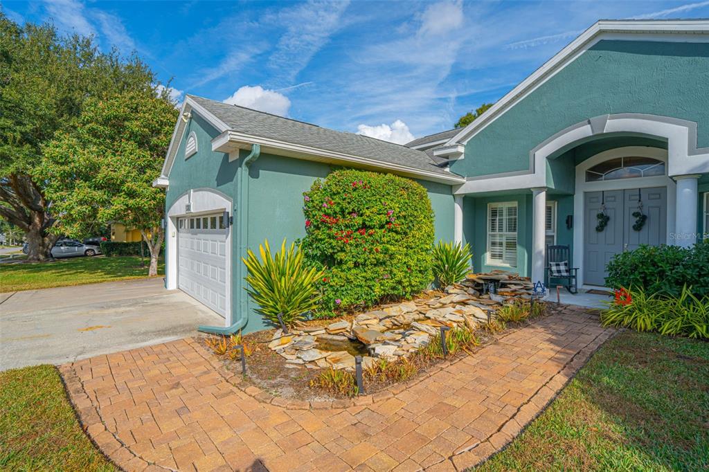 A teal house with a stone walkway, a small rock pond, and a two-car garage — 1381 SHELTER ROCK ROAD, ORLANDO, FL