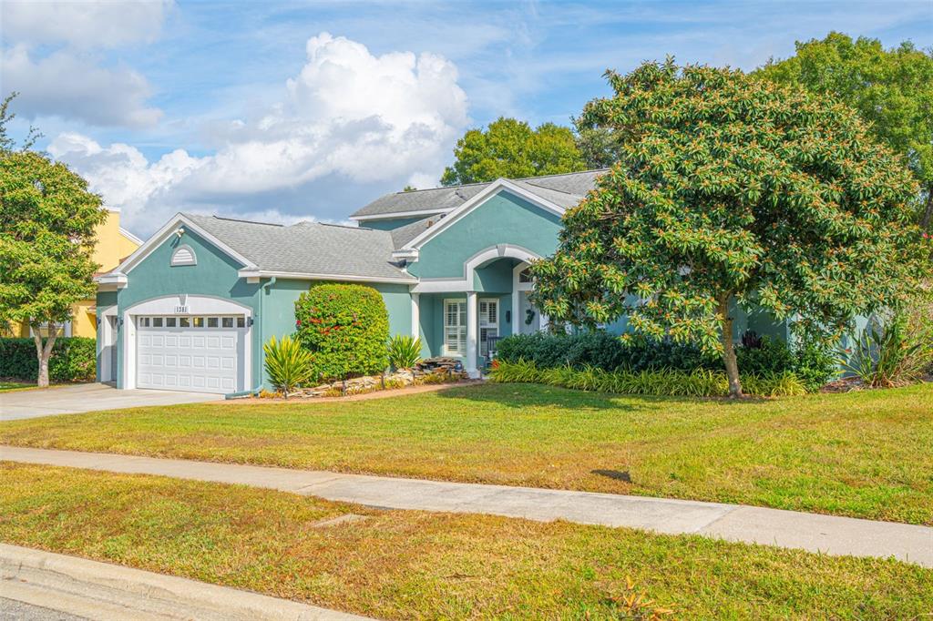 A teal, single-story suburban house with a two-car garage and a large front yard — 1381 SHELTER ROCK ROAD, ORLANDO, FL