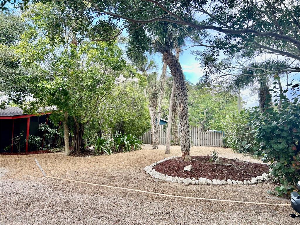 An aerial view shows a waterfront house surrounded by lush trees and a canal — 4830 HIGEL AVENUE, SARASOTA, FL