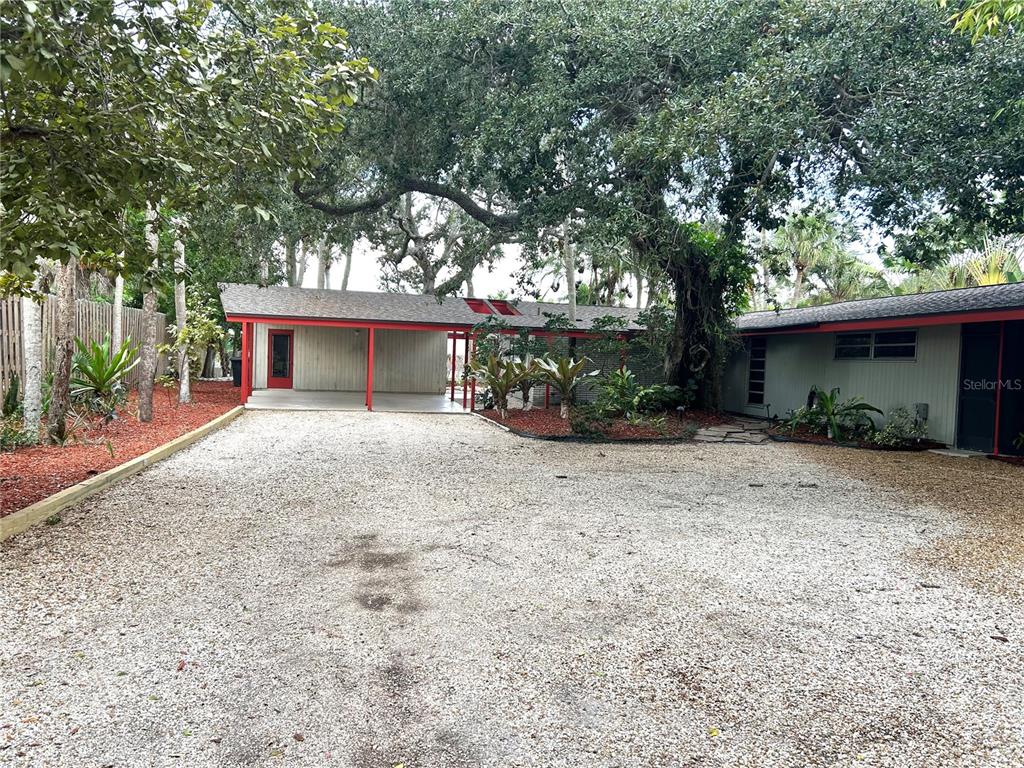 An aerial view shows a waterfront residential neighborhood with a house circled in white — 4830 HIGEL AVENUE, SARASOTA, FL