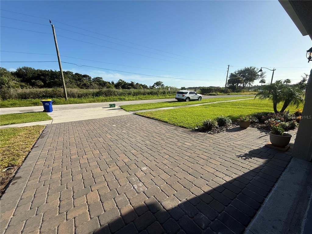A paved driveway leads to a grassy front yard with a parked white SUV nearby — 182 JONES FISH CAMP ROAD, EDGEWATER, FL