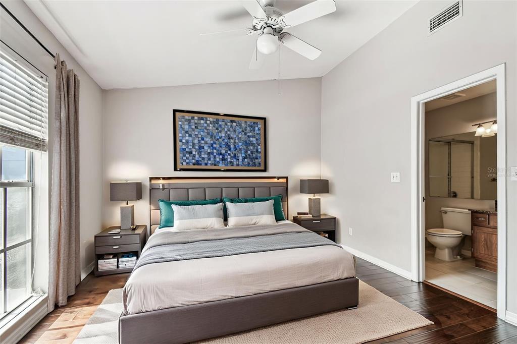 A bedroom features a bed with grey bedding, two nightstands, and an attached bathroom — 609 S GLEN AVENUE UNIT E, TAMPA, FL