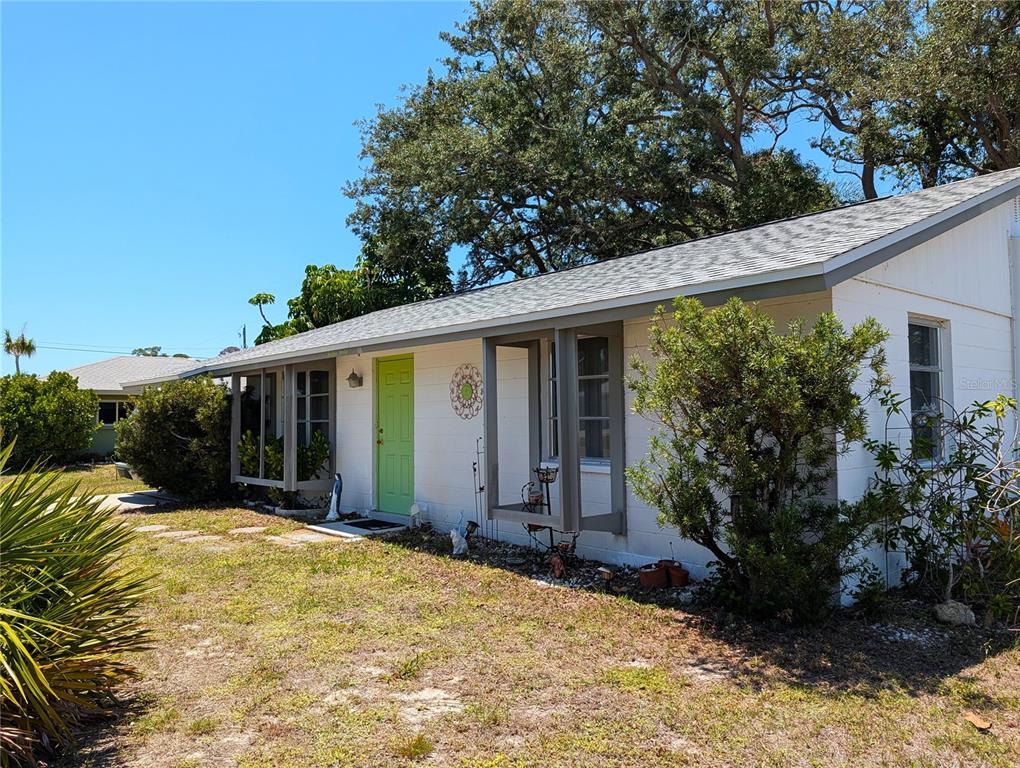 A white single-story house with a lime green front door and two bay windows — 1240 S VENICE BOULEVARD, VENICE, FL