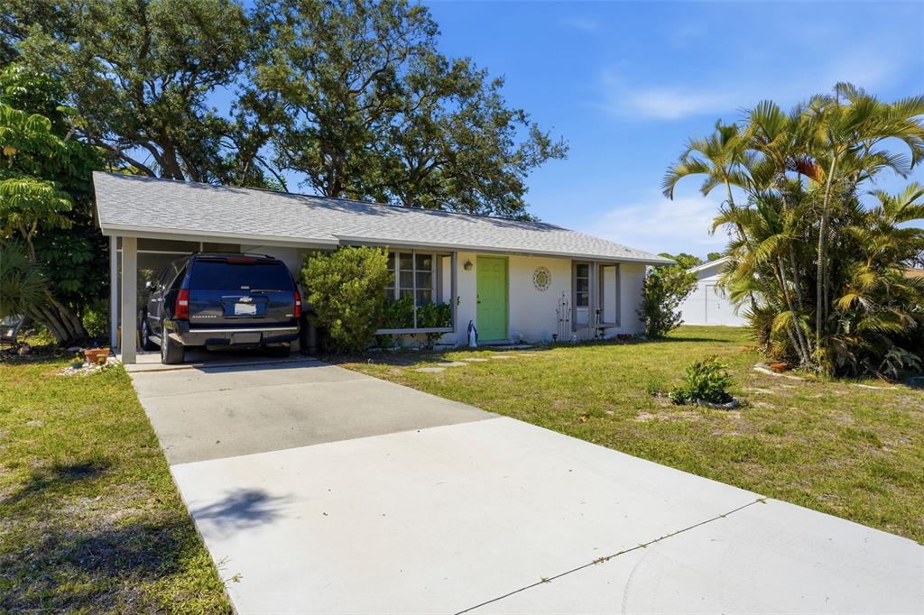 A single-story house with a light-colored exterior, a lime green front door, and a carport — 1240 S VENICE BOULEVARD, VENICE, FL