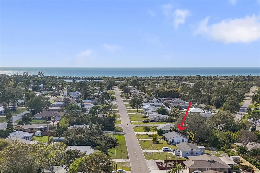 An aerial view shows a residential neighborhood with a red arrow pointing to a house — 1240 S VENICE BOULEVARD, VENICE, FL