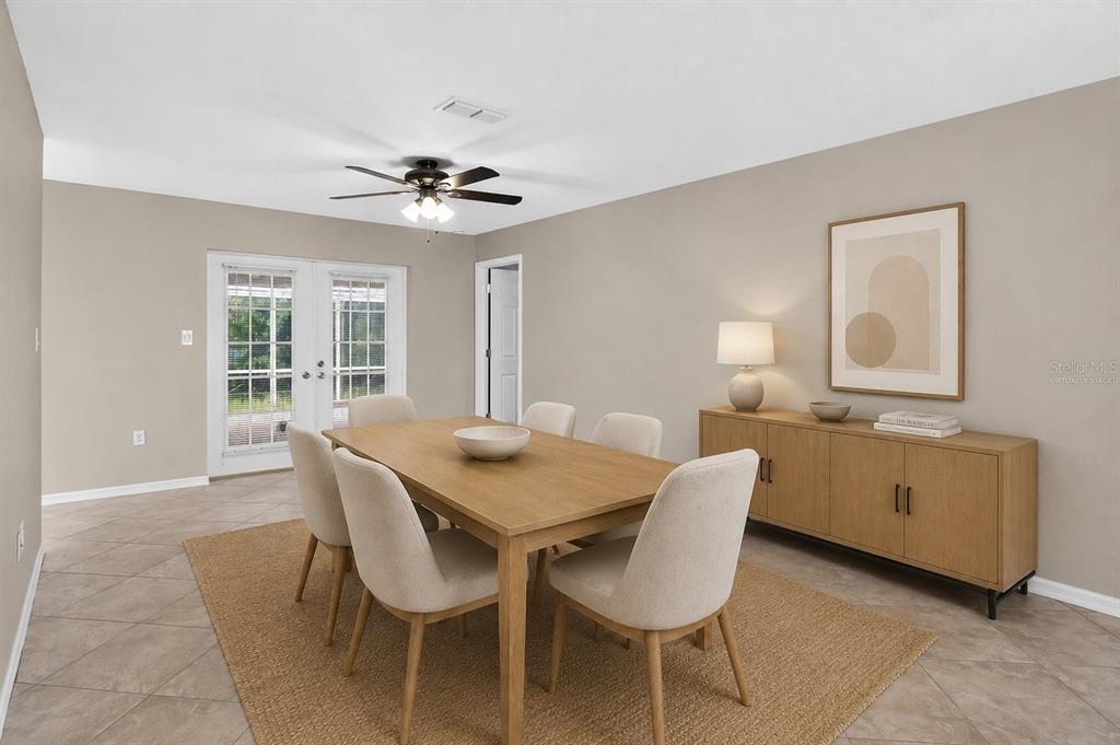 A dining room with a wooden table, six chairs, a sideboard, and French doors — 9504 VIA SEGOVIA, NEW PORT RICHEY, FL