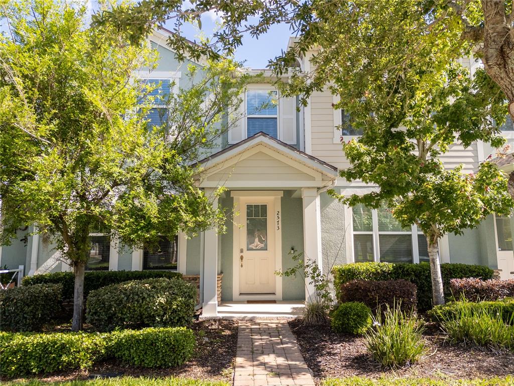 A two-story house with a light green exterior, a front porch, and a brick walkway — 2573 FOLIO WAY, KISSIMMEE, FL