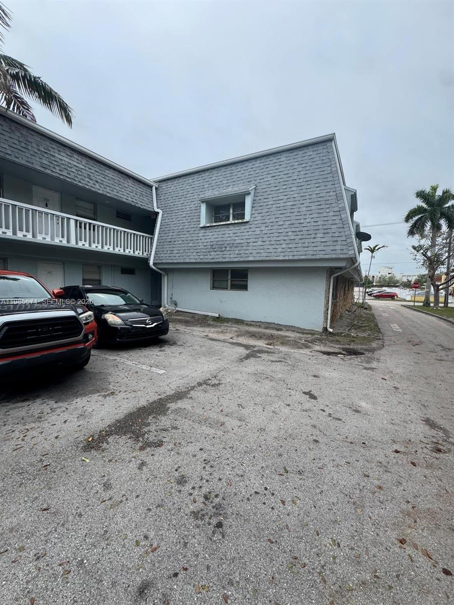 An exterior view of a two-story apartment building with a parking lot in front — 4251 NW 5th St # 106, Plantation FL 33317, PLANTATION, FL