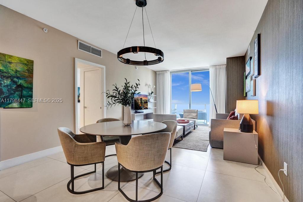 A dining area with a round table and chairs sits adjacent to a living room — 4111 S Ocean Dr # 2803, Hollywood FL 33019, HOLLYWOOD, FL