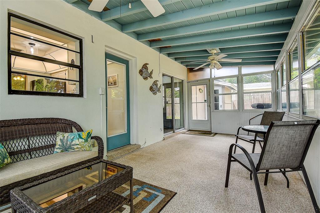 A screened-in porch with a blue ceiling, wicker furniture, and a textured concrete floor — 6237 DALTON STREET, SPRING HILL, FL