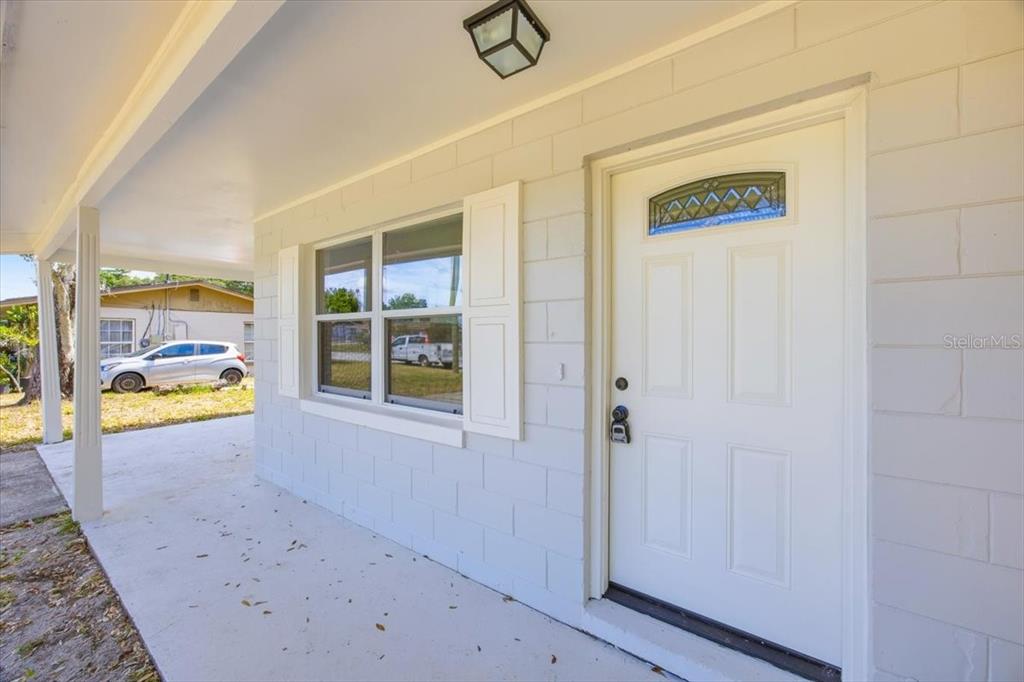 A bright, empty living room features light-colored wood-look flooring, white walls, and a ceiling fan — 827 EVERETT STREET, LAKE ALFRED, FL