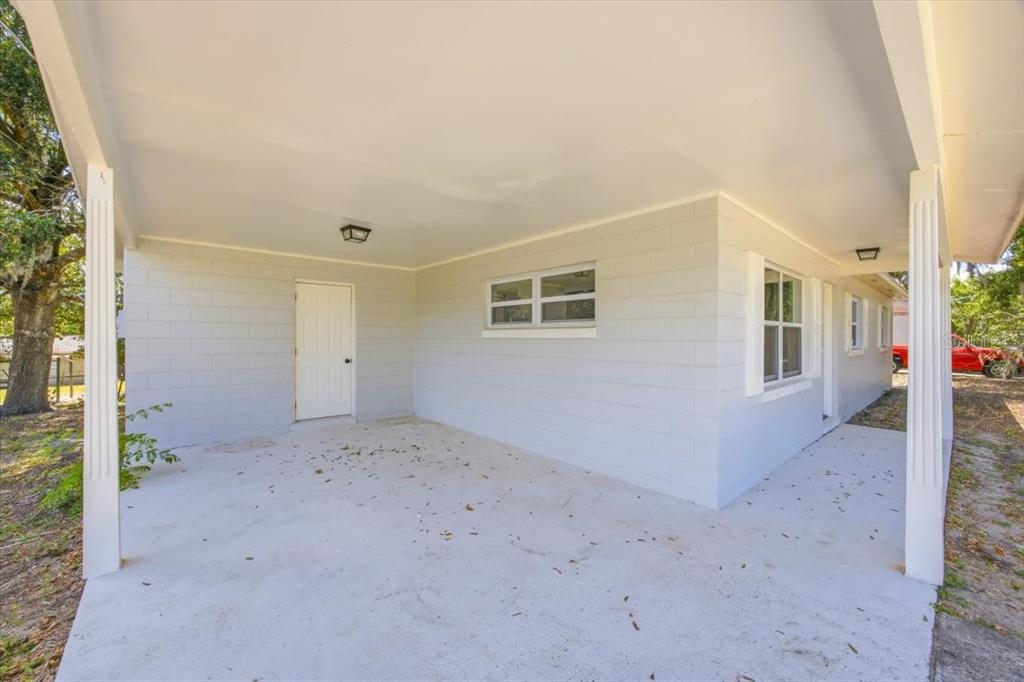 A bright living room features light wood-look flooring, white walls, and a ceiling fan — 827 EVERETT STREET, LAKE ALFRED, FL