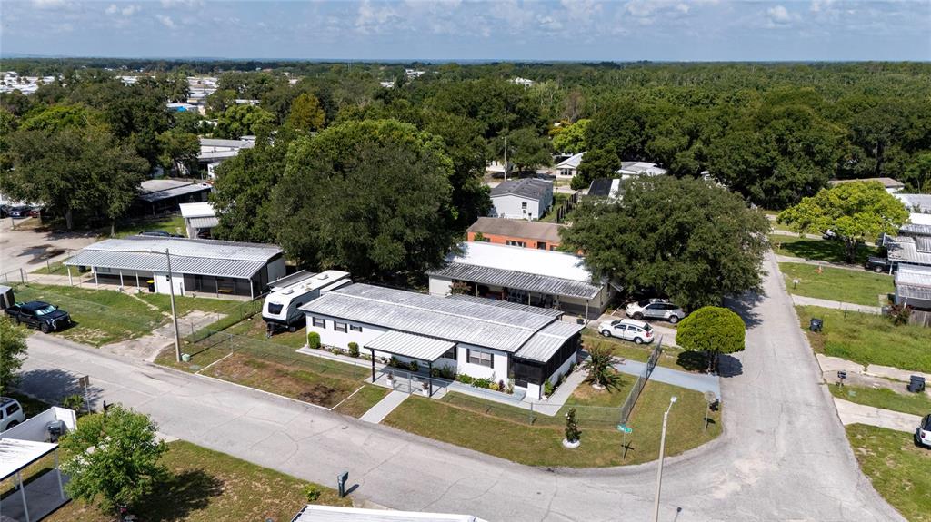 An aerial view shows a single-story mobile home with a metal roof and attached carport — 24 FLAMINGO BOULEVARD, WINTER HAVEN, FL