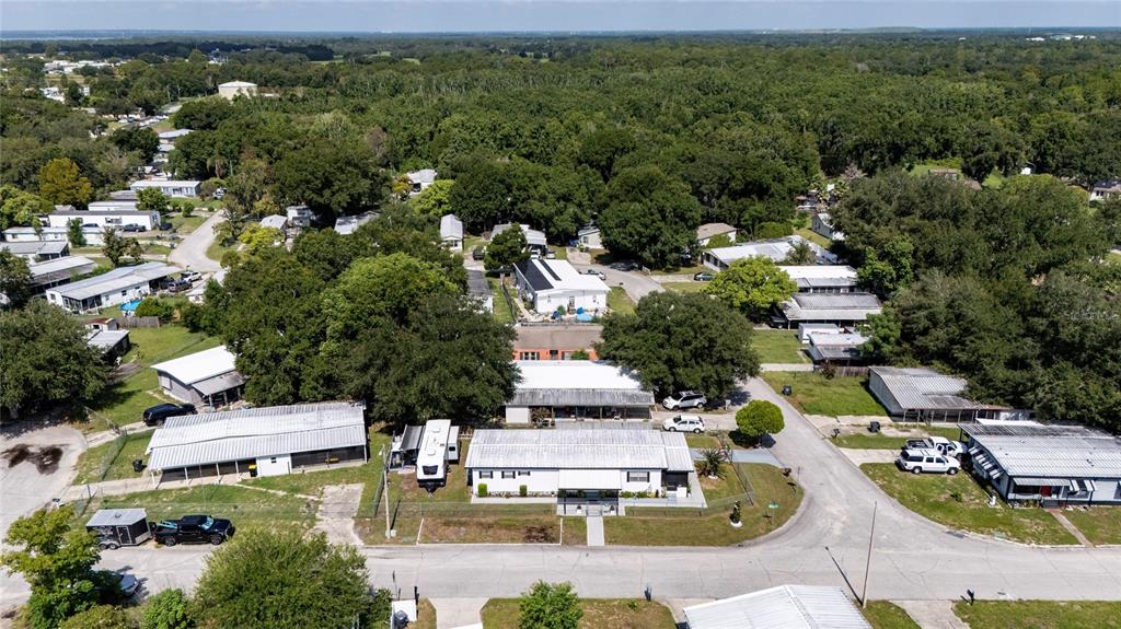 An aerial view shows several mobile homes and houses nestled among many mature green trees — 24 FLAMINGO BOULEVARD, WINTER HAVEN, FL