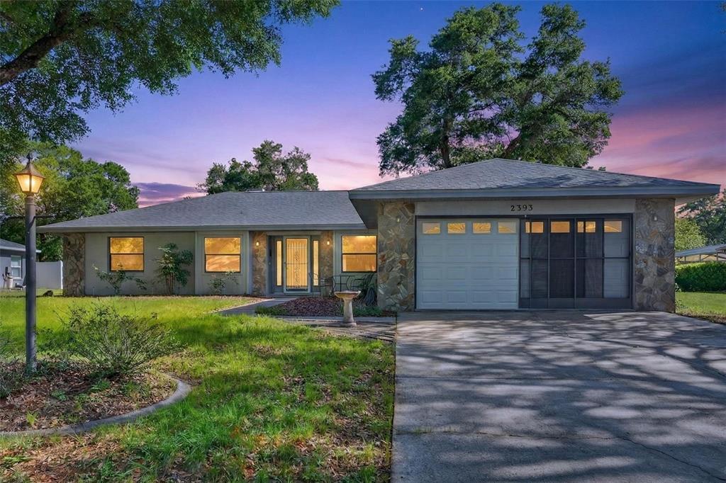A single-story house with a stone facade, a one-car garage, and a concrete driveway — 2393 W FAIRWAY LOOP, CITRUS SPRINGS, FL