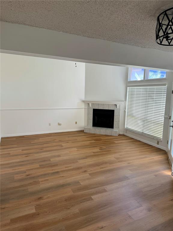A living room features wood-look flooring, a corner fireplace, and a large window with blinds — 4424 DUNWOODY PLACE UNIT 13, ORLANDO, FL