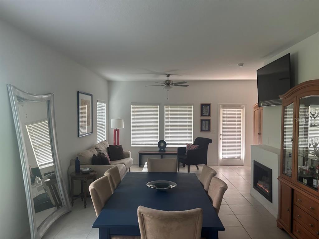 A dining area with a dark blue table sits in front of a living room — 870 TENNYSON MILL CIRCLE, TAMPA, FL