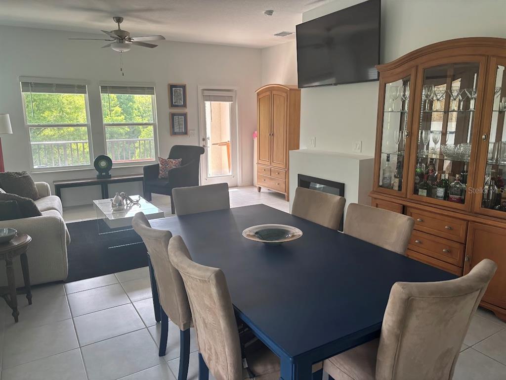 A dining area with a dark blue table sits adjacent to a living room space — 870 TENNYSON MILL CIRCLE, TAMPA, FL