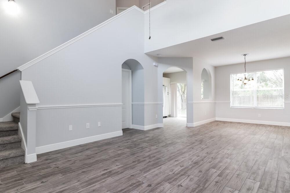 An interior view of a living area with gray wood-look flooring and a staircase — 18034 BIRDWATER DRIVE, TAMPA, FL
