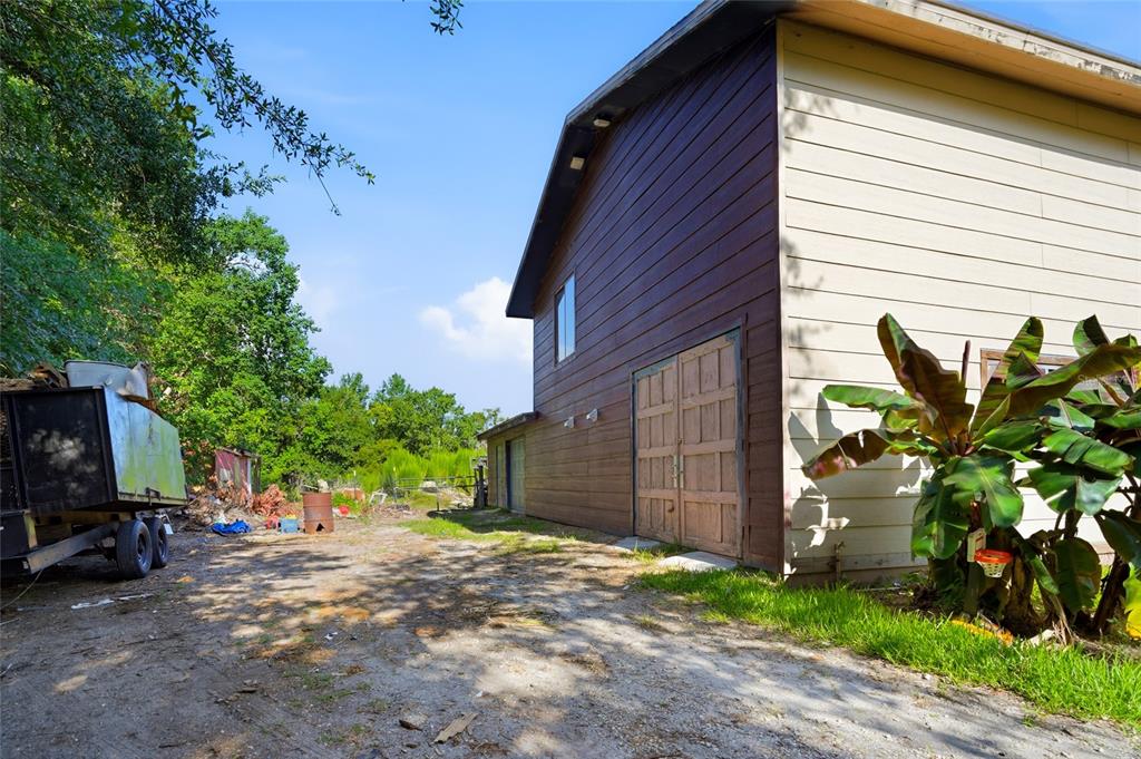 A two-story building with brown wood siding and a large double door exterior entrance — 2347 BROOKSIDE DRIVE, LUTZ, FL