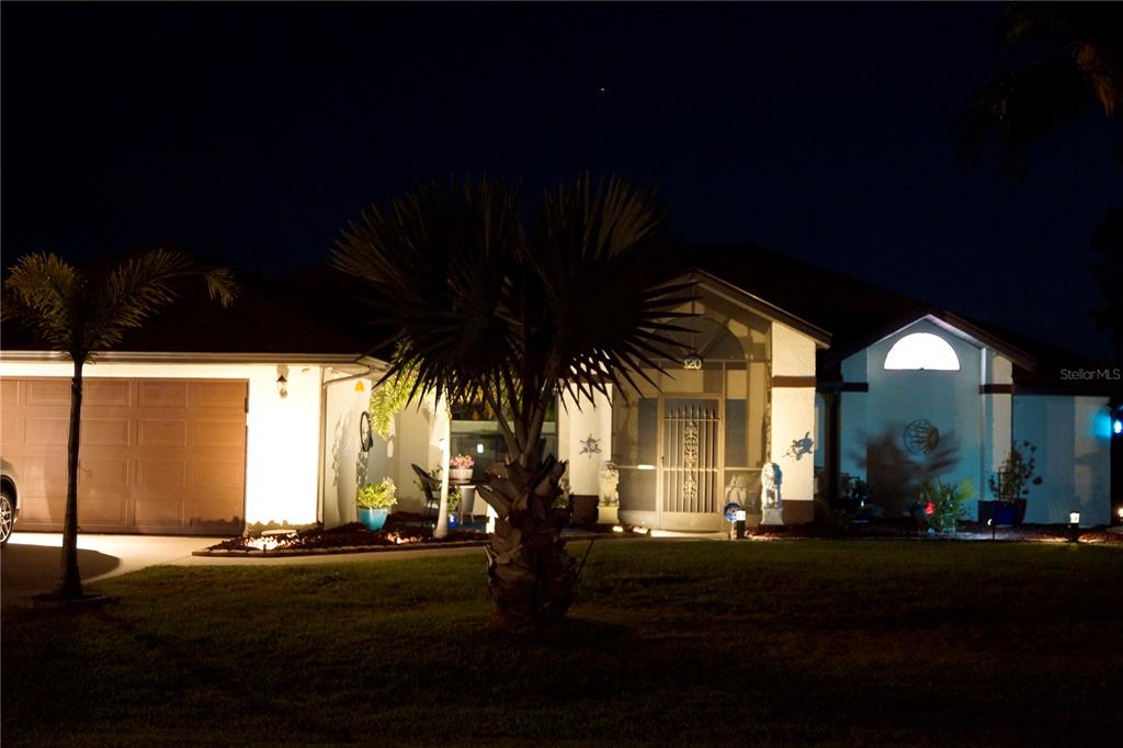 A single-story house with a garage and a palm tree at night — 120 CUIABA DRIVE, PUNTA GORDA, FL