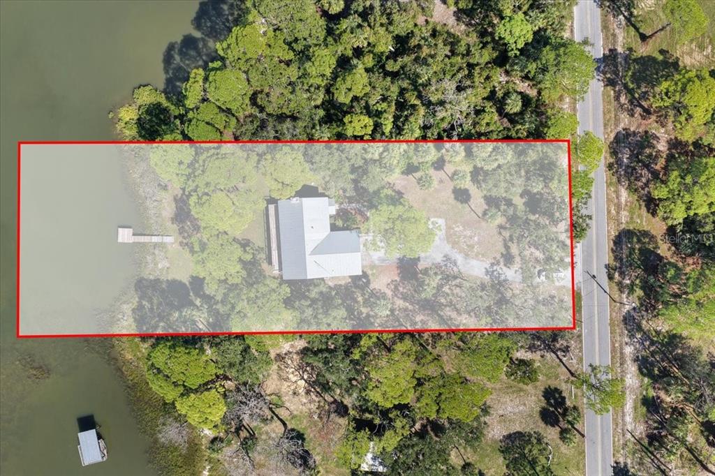 An aerial view shows a house on a waterfront lot with a private dock — 16931 SW 133RD STREET, CEDAR KEY, FL