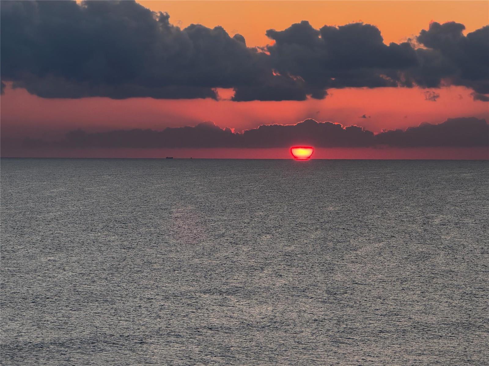 A vibrant red sunset dips below the horizon over a calm, dark ocean — 10600 S Ocean Drive # 1103, Jensen Beach FL 34957, JENSEN BEACH, FL