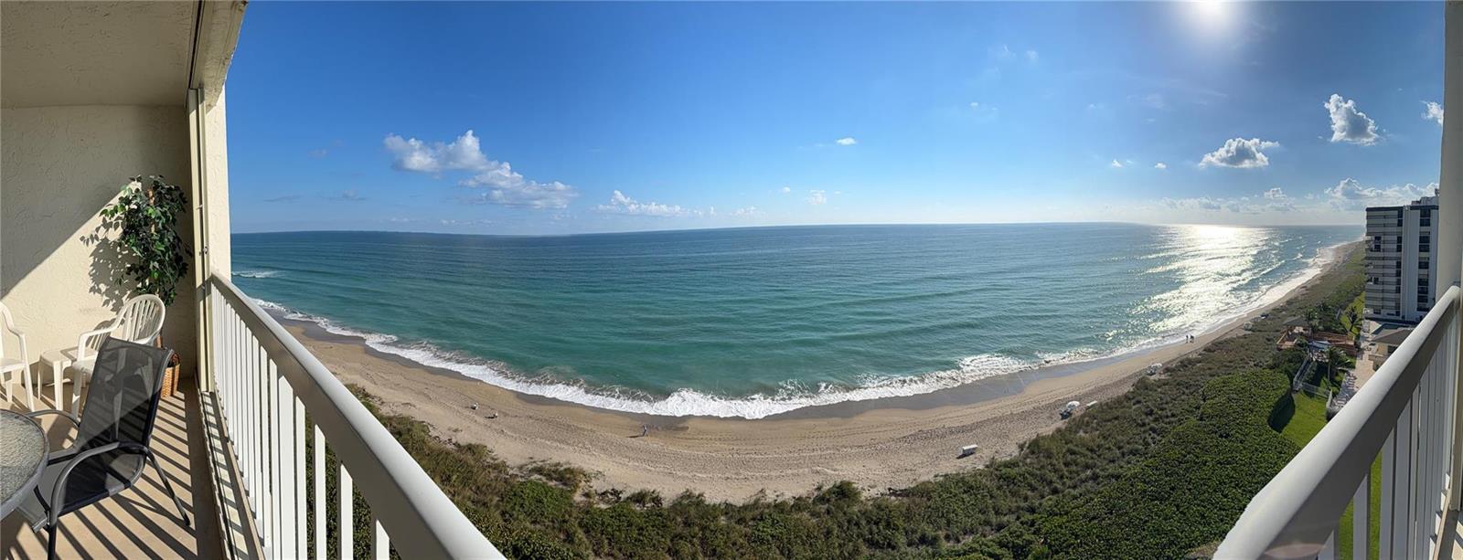 A balcony view overlooking a sandy beach and the ocean under a clear blue sky — 10600 S Ocean Drive # 1103, Jensen Beach FL 34957, JENSEN BEACH, FL