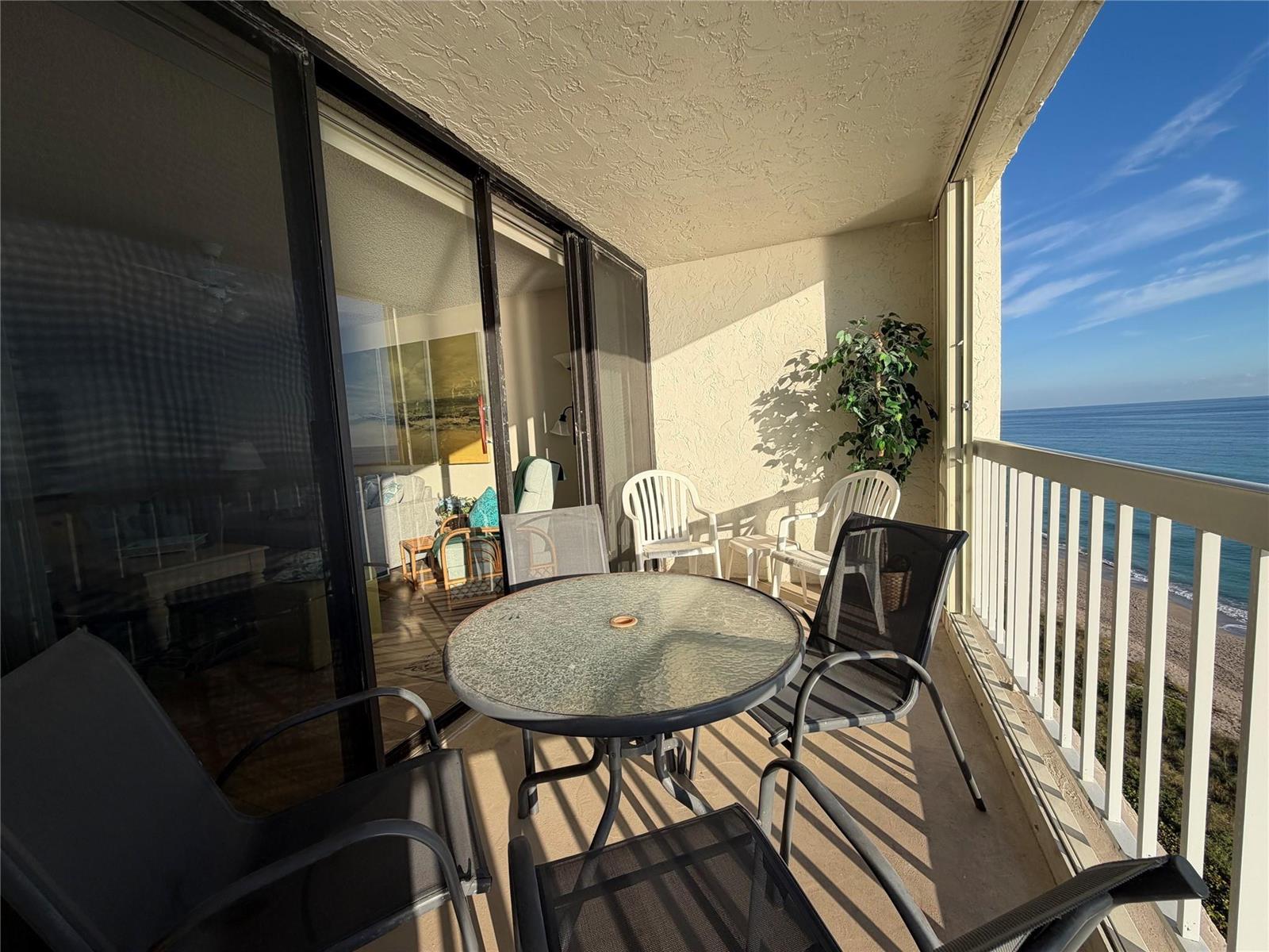 A balcony with a glass-topped table and chairs overlooks the ocean — 10600 S Ocean Drive # 1103, Jensen Beach FL 34957, JENSEN BEACH, FL