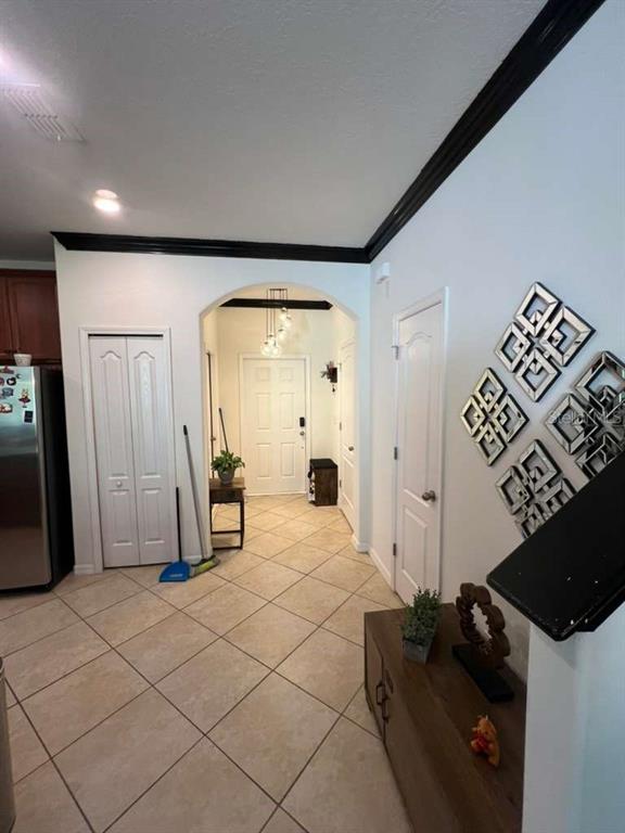 A tiled entryway features an arched doorway, white doors, and decorative wall art — 6453 SEDGEFORD DRIVE, LAKELAND, FL