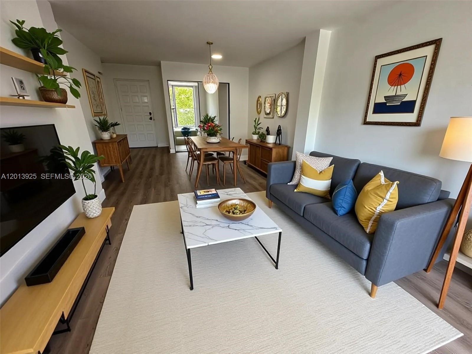 A living room with a grey sofa, marble coffee table, and adjacent dining area — 777 NE 62nd St # C306, Miami FL 33138, MIAMI, FL
