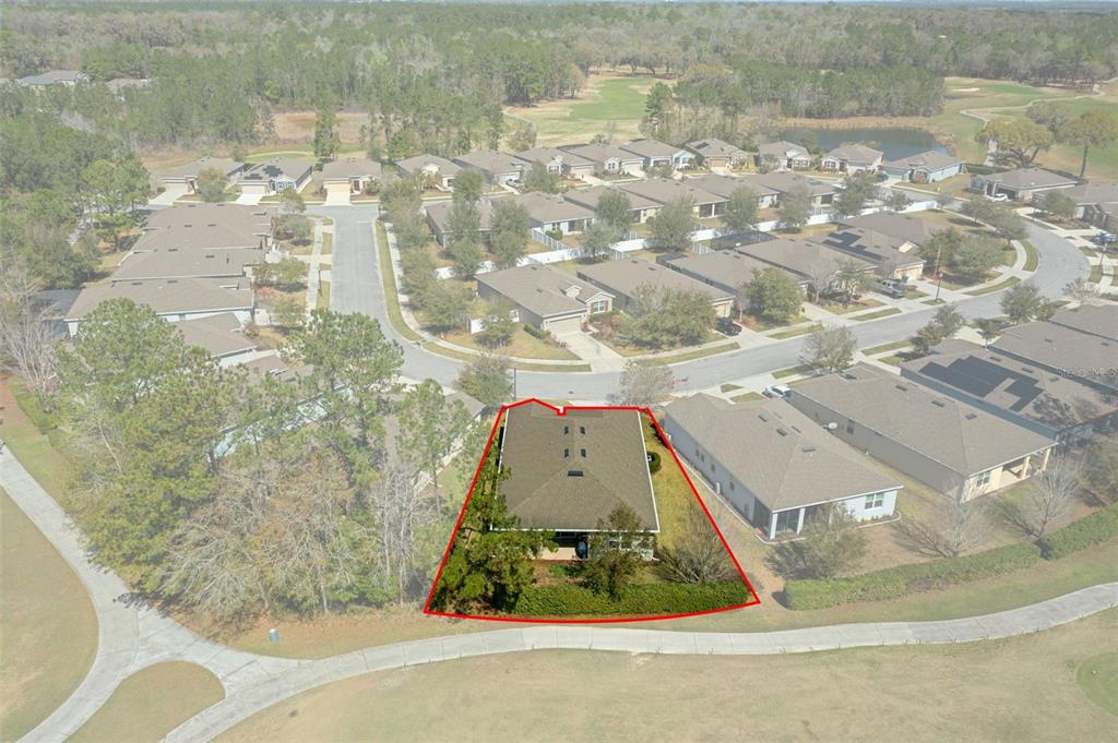 An aerial view shows a single-family home outlined in red, situated on a golf course — 17807 GARSALASO CIRCLE, BROOKSVILLE, FL