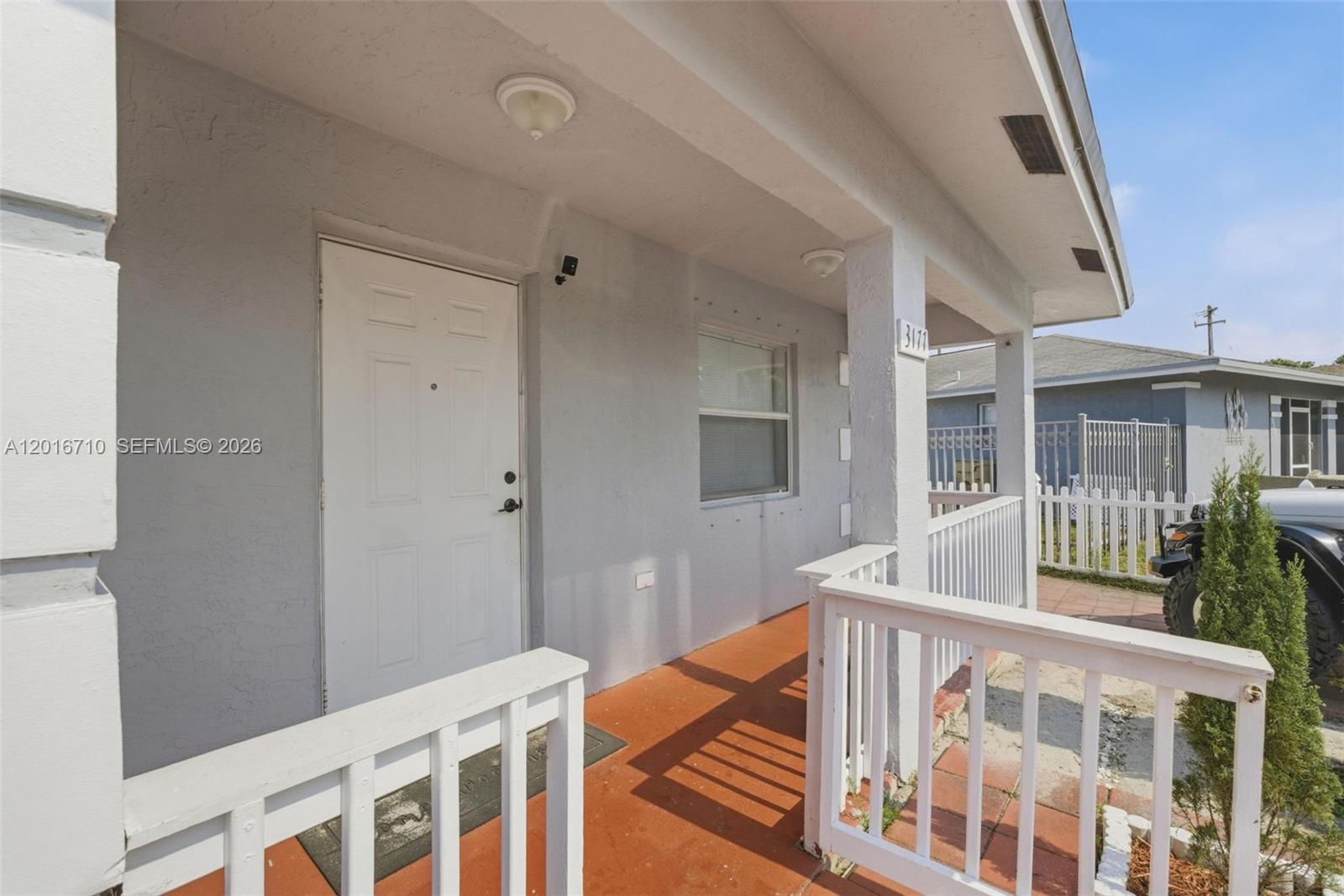 A white front door opens onto a covered porch with a white railing — 3177 NW 75th Way, Hollywood FL 33024, HOLLYWOOD, FL